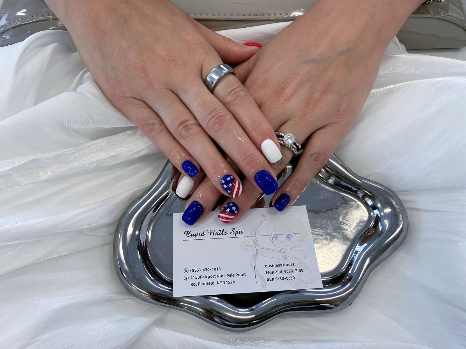 Square nails in royal blue and white with two accent nails painted as the American flag, stars and stripes